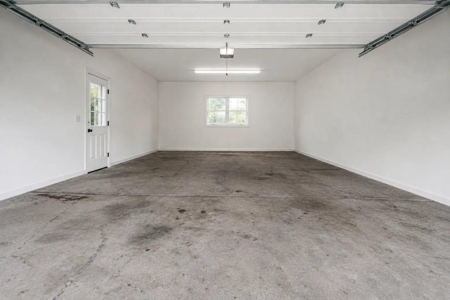 The same garage before coating, stained and cracked bare concrete