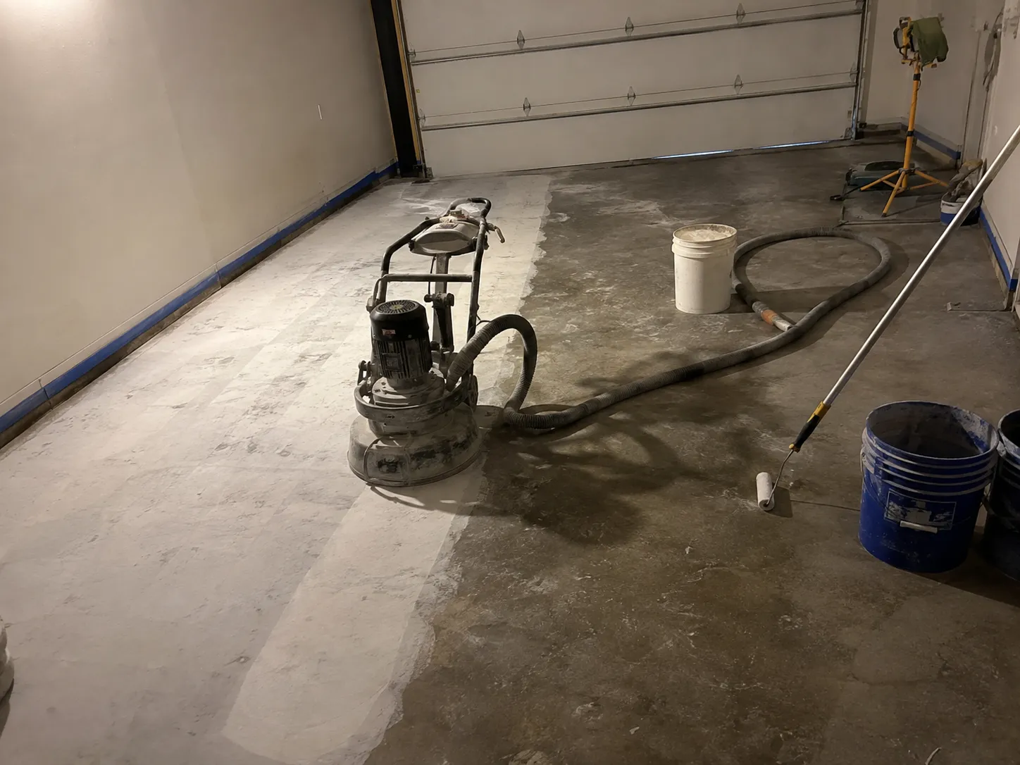 Garage mid-project with tools and dust during the diamond-grinding prep